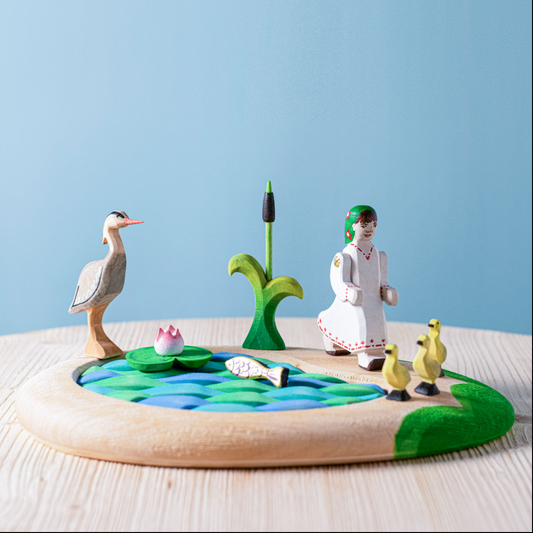 Ensemble lac, quenouilles, nénuphar, poisson, héron, fille et canetons